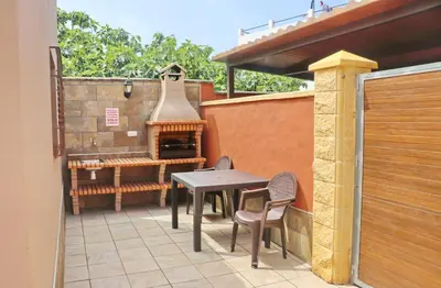 a patio with a table and chairs and a stove at Chalet Sultan con piscina in Conil de la Frontera