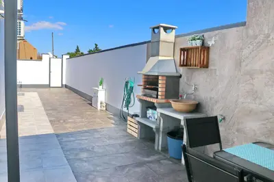 a patio with a grill on the side of a building at Chalet moderno con pisicina in Conil de la Frontera