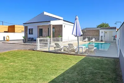 a deck with a pool and a table and an umbrella at Chalet moderno con pisicina in Conil de la Frontera