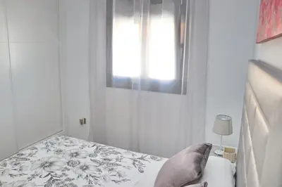 a small bedroom with a bed and a window at Chalet moderno con pisicina in Conil de la Frontera