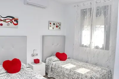 two red hearts on two beds in a white room at Chalet moderno con pisicina in Conil de la Frontera