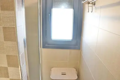 a bathroom with a shower with a toilet and a window at Chalet moderno con pisicina in Conil de la Frontera