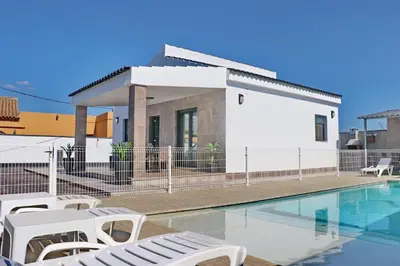 a villa with a swimming pool and a house at Chalet moderno con pisicina in Conil de la Frontera