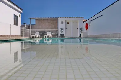 a swimming pool with two chairs and a basketball at Chalet moderno con pisicina in Conil de la Frontera
