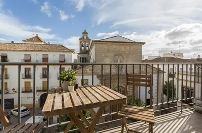 a wooden table and chair on a balcony at Luxe Vista Histórico 5 rooms 4 baños in Jerez de la Frontera