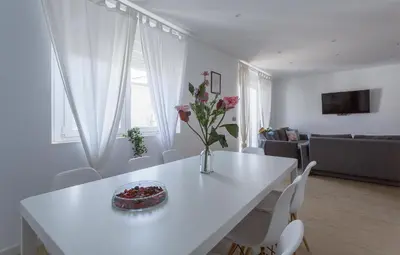 a white dining room table with a vase of flowers on it at Luxe Vista Histórico 5 rooms 4 baños in Jerez de la Frontera