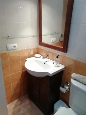 a bathroom with a sink and a mirror and a toilet at Apartamento en rota in Rota