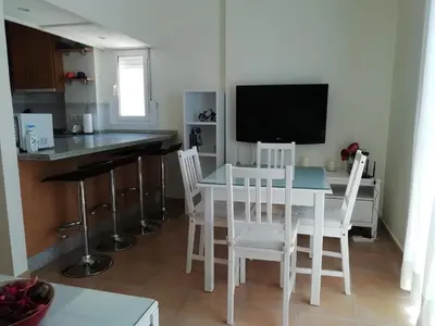 a kitchen and dining room with a white table and chairs at Apartamento en rota in Rota