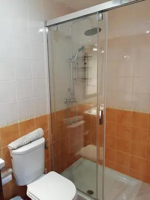 a bathroom with a toilet and a glass shower at Apartamento en rota in Rota