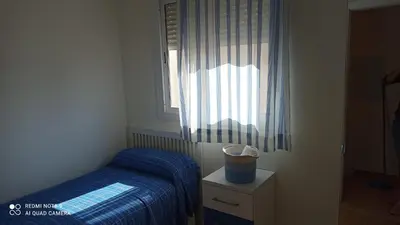 a small bedroom with a bed and a window at Apartamento en rota in Rota