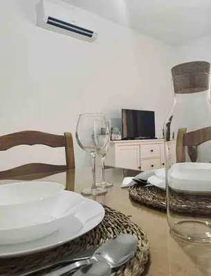 a dining room table with a plate and wine glasses at Apartamento Felisa in Arcos de la Frontera