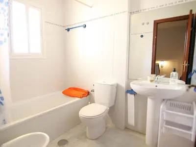 a white bathroom with a toilet and a sink at Holiday Home Brisamar - Novo Sancti Petri by Interhome in Chiclana de la Frontera