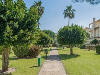 a path in a park with trees and a building at Holiday Home Brisamar - Novo Sancti Petri by Interhome in Chiclana de la Frontera