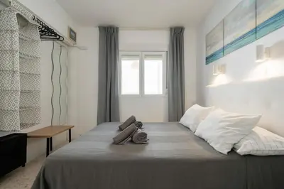 a bedroom with a large bed with a window at Cádiz Beach & Kids - free parking - sea views in Cádiz