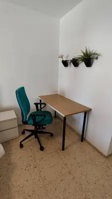 a desk and a green chair in a room at Cádiz Beach & Kids - free parking - sea views in Cádiz
