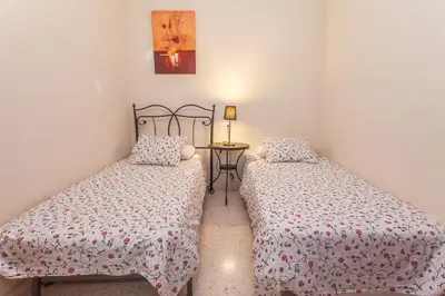 two beds in a small room with a table at Apartamento Centro Jerez in Jerez de la Frontera