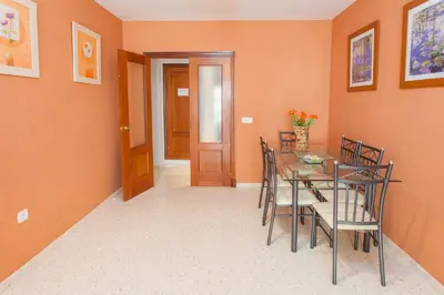 a dining room with orange walls and a table and chairs at Apartamento Centro Jerez in Jerez de la Frontera