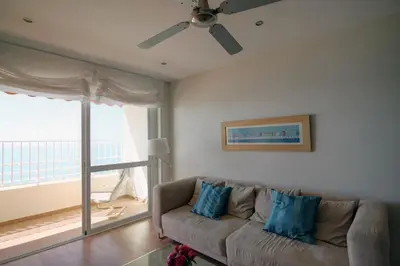 a living room with a couch and a ceiling fan at Apartamento Playa Victoria Cadiz in Cádiz