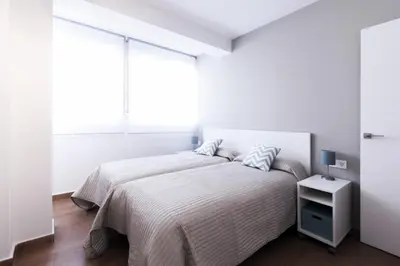 a white bedroom with a bed and a window at Apartamento La Terraza del Mar in Cádiz