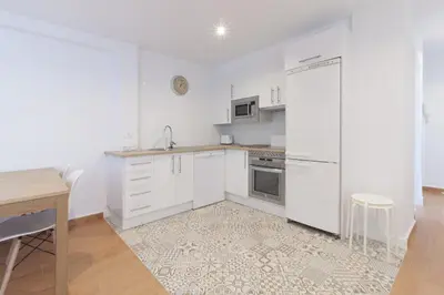a kitchen with white cabinets and a white refrigerator at Apartamento La Terraza del Mar in Cádiz