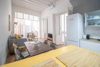 a kitchen and living room with a table and chairs at Apartamentos Las Musas de Cadiz in Cádiz