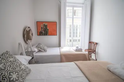 a bedroom with two beds and a window at Apartamentos Las Musas de Cadiz in Cádiz