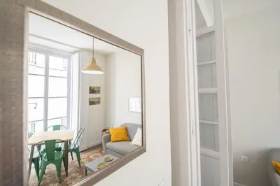 a mirror in a living room with a table and a couch at Apartamentos Las Musas de Cadiz in Cádiz