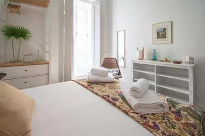 a bedroom with a bed with towels on it at Apartamentos Las Musas de Cadiz in Cádiz
