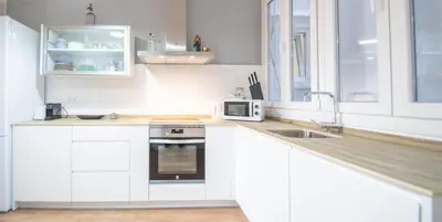 a white kitchen with a sink and a microwave at Apartamentos Las Musas de Cadiz in Cádiz
