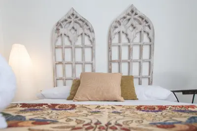 a bedroom with a bed with two gothic windows at Apartamentos Las Musas de Cadiz in Cádiz