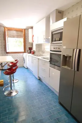a kitchen with white appliances and blue tile floors at El Rincon de Elena (Garden Apartment) in Jerez de la Frontera