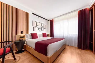a bedroom with a large bed and a red chair at Boutique Hotel OLOM - Only Adults recommended in Cádiz