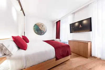 a bedroom with a large bed and a flat screen tv at Boutique Hotel OLOM - Only Adults recommended in Cádiz