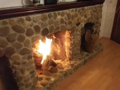 a stone fireplace with a fire in it at El Lagar de los Abuelos in Arcos de la Frontera