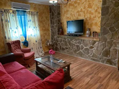 a living room with a couch and a tv at El Lagar de los Abuelos in Arcos de la Frontera