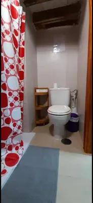 a bathroom with a white toilet and a red and white curtain at Cathedral two bedroom unit & two balconies in Cádiz