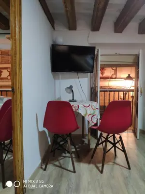 a room with two red chairs and a table and a tv at Cathedral two bedroom unit & two balconies in Cádiz