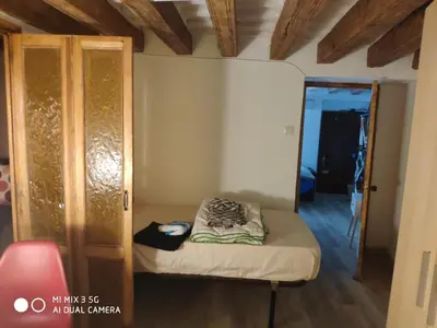 a small room with a bed and a door at Cathedral two bedroom unit & two balconies in Cádiz
