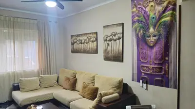 a living room with a couch and a painting on the wall at A 50 metros de la playa in Cádiz