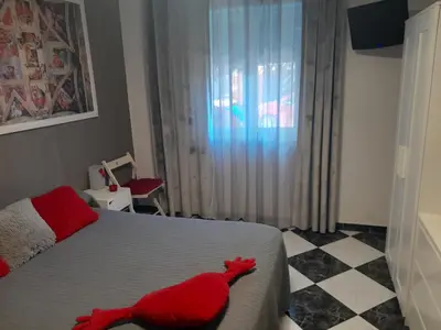 a bedroom with a red animal on the bed at A 50 metros de la playa in Cádiz