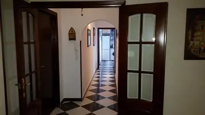 a hallway with doors and a checkered floor at A 50 metros de la playa in Cádiz