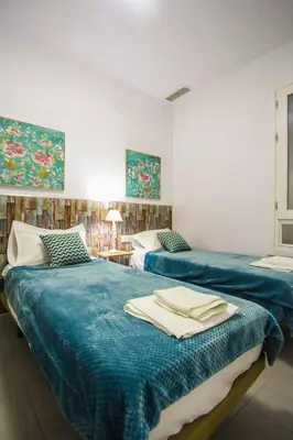 two beds with blue sheets in a room at SH Cruz. Moderno apartmento cerca del Mercado. in Cádiz