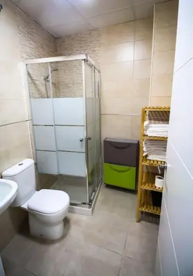 a bathroom with a toilet and a glass shower at SH Cruz. Moderno apartmento cerca del Mercado. in Cádiz