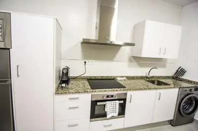a white kitchen with a sink and a stove at SH Cruz. Moderno apartmento cerca del Mercado. in Cádiz