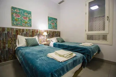 two beds in a room with blue sheets and towels at SH Cruz. Moderno apartmento cerca del Mercado. in Cádiz