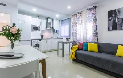 a living room with a couch and a kitchen at El Balneario in Cádiz