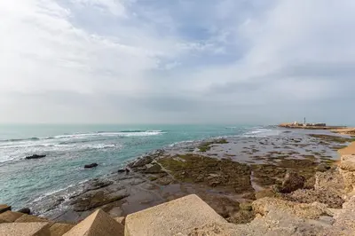a view of the ocean from a rocky beach at El Balneario in Cádiz