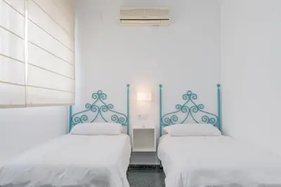 two beds in a room with blue and white walls at Sherryflat Casa del Arquitecto in Jerez de la Frontera