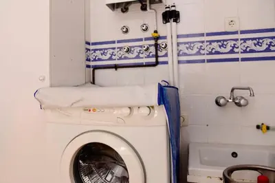 a bathroom with a washing machine and a tub at Charming house in Rota + garden in Rota