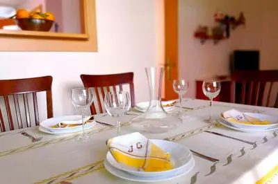 a table with plates and wine glasses on it at Charming house in Rota + garden in Rota